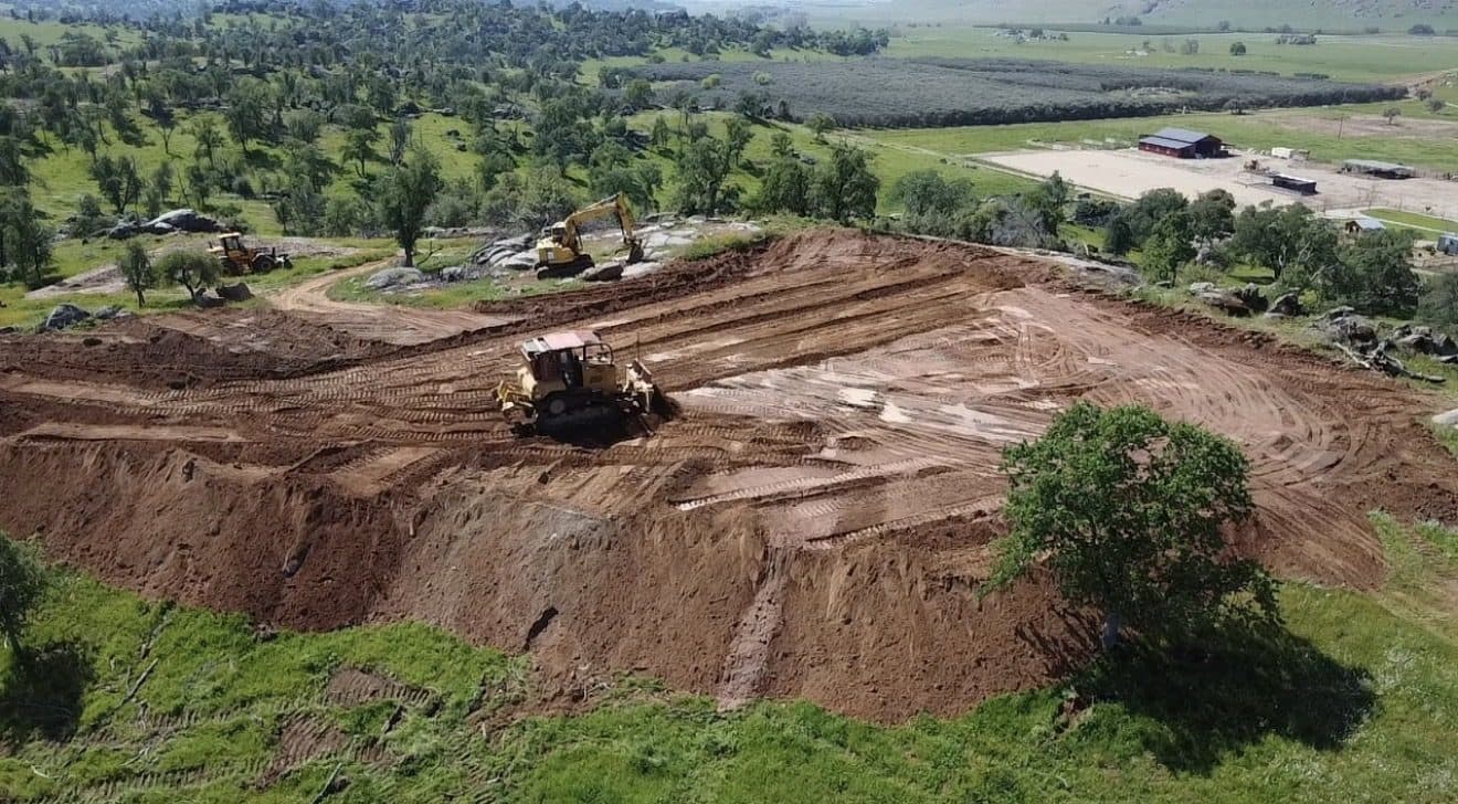 Aerial view of earthwork and pad construction with a dozer and excavator
