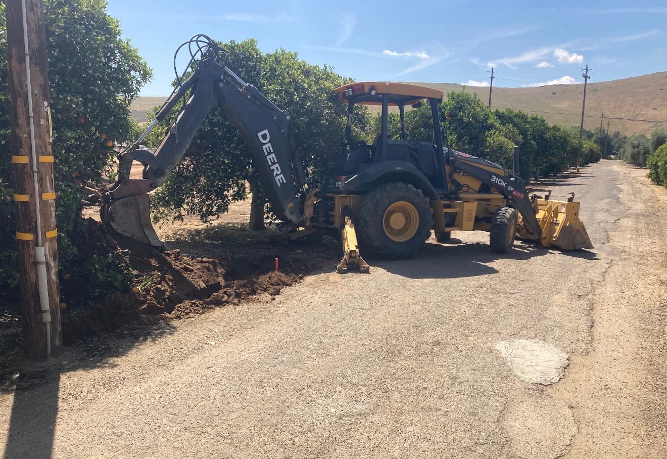 Excavator digging trenches for underground work on a job site
